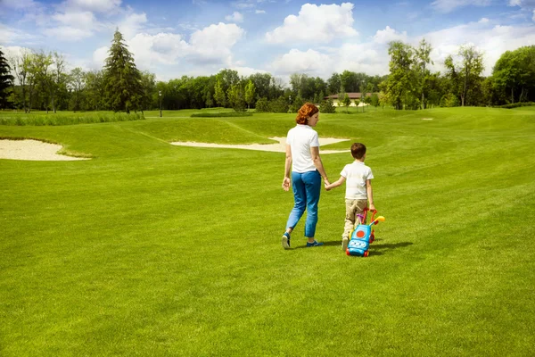 Moeder onderwijs zoon om golf te spelen — Stockfoto