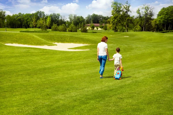 Madre enseñando hijo a jugar golf — Foto de Stock