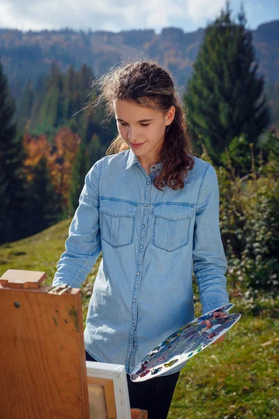 Giovane pittore al lavoro in montagna — Foto Stock