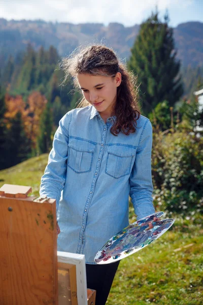 Jovem pintor a trabalhar nas montanhas — Fotografia de Stock