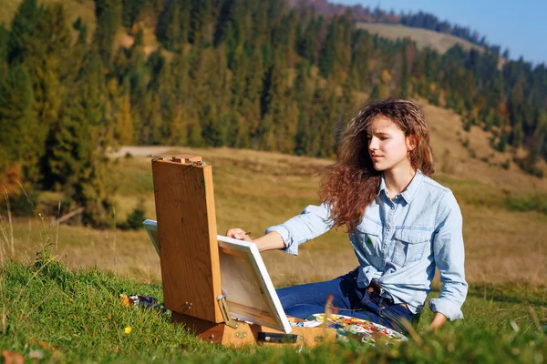 Jonge schilder op het werk in de bergen — Stockfoto