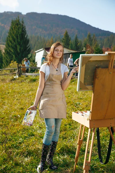 Jonge schilder op het werk in de bergen — Stockfoto
