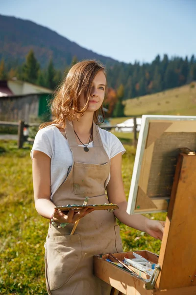 Giovane pittore al lavoro in montagna — Foto Stock