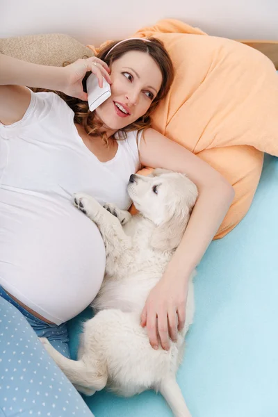 Mulher grávida com seu cão em casa — Fotografia de Stock