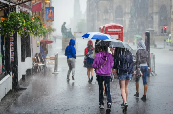 Gruppo di ragazze che camminano sotto la pioggia estiva in città — Foto Stock