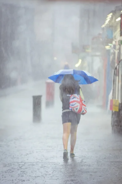 Chica caminando en la lluvia de verano en la ciudad —  Fotos de Stock