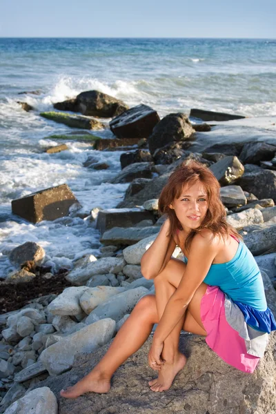 Une jeune fille sur le fond de la mer est assise sur un rocher — Photo