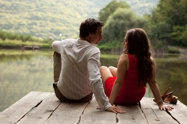 Uomo e donna seduti a guardarsi mentre si siedono sulla — Foto Stock