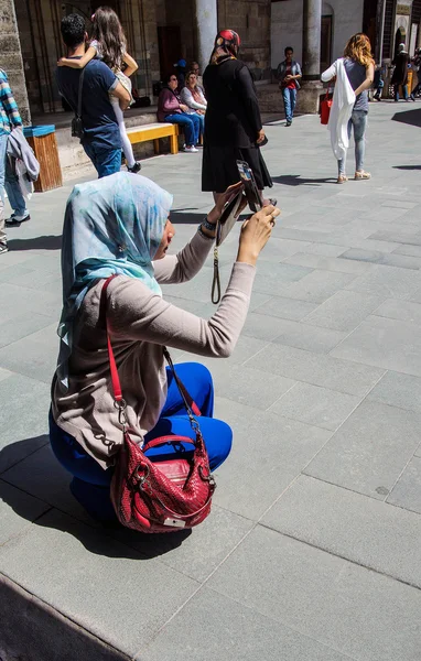 Young Turkish woman photographs friends