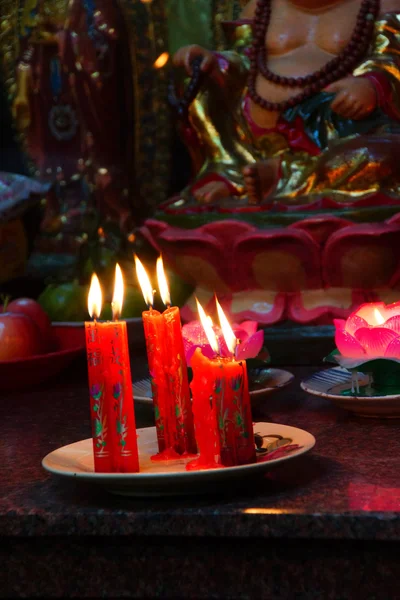 Votive candles and incense, with Buddha