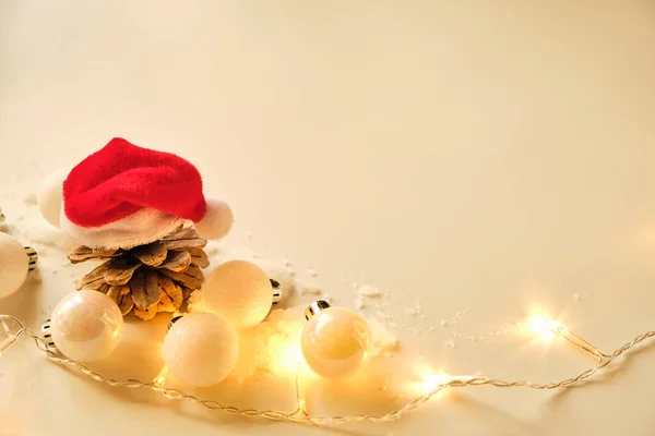 Karácsonyi Háttér Fehér Csillogó Golyók Koszorúslámpák Fenyőtoboz Télapó Kalap Másolás — Stock Fotó