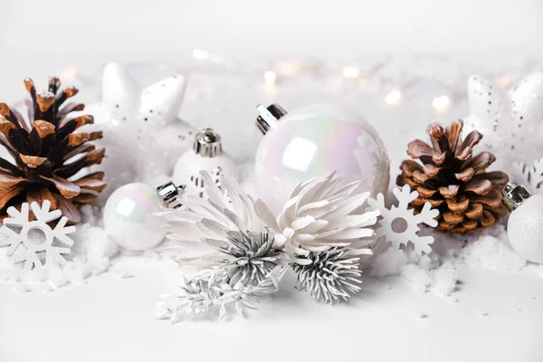 Silver and white Christmas balls. X-mas ornaments on white snow background merry christmas card winter holidays theme. Close-up. Copy space.