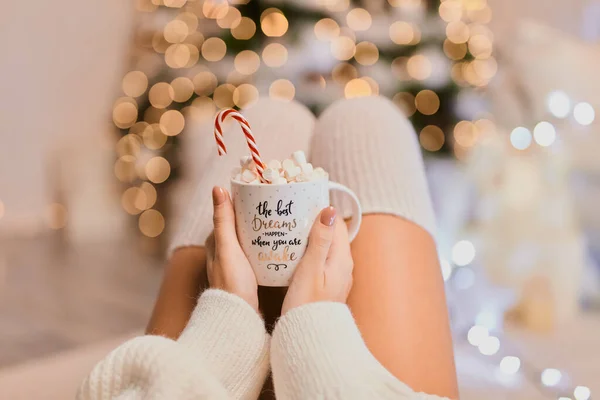 明るいクリスマスライトに対して若い女の子の手に暖かいココアのカップのクローズアップショット お祭りのクリスマス気分 — ストック写真