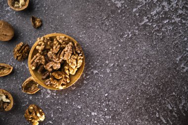 Siyah arka planda ahşap kasede ceviz ve fotokopi alanı. Üst Manzara. Siyah arka planda soyulmuş ceviz kaplı ahşap bir tabak. Metin için boşluk