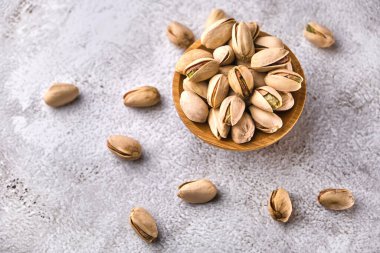 Gri masadaki tahta kasede organik şam fıstığı. Metin için boşluk