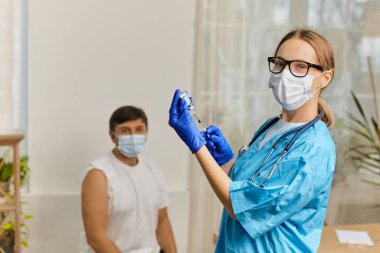 Genç kadın doktor Coronavirus Covid 'e karşı aşı yaptırıyor. 19 yaşında, klinikteki genç bir adama.