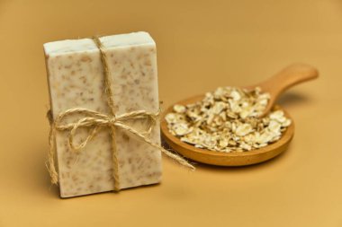 Bej arka planda el yapımı doğal banyo yulaf spa sabunu. Tahta bir kasede sabun ve yulaf ezmesi. Sabun kalıpları. Spa, deri ve vücut bakımı. Hediye paketi.