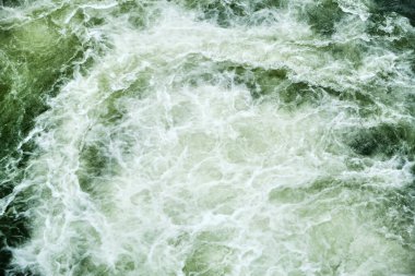 Bir şelaleden gelen dalgaların dalgaları yüksek gelgit ve alçak gelgit sırasında bir dağ nehrine akar. Suyun girdapları