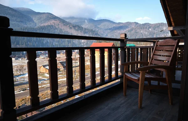 Incredible Mountain View landscape from the hotel balcony. Handmade wicker chair as a decorative element. Winter vacation. Concept of recreation in the mountains.