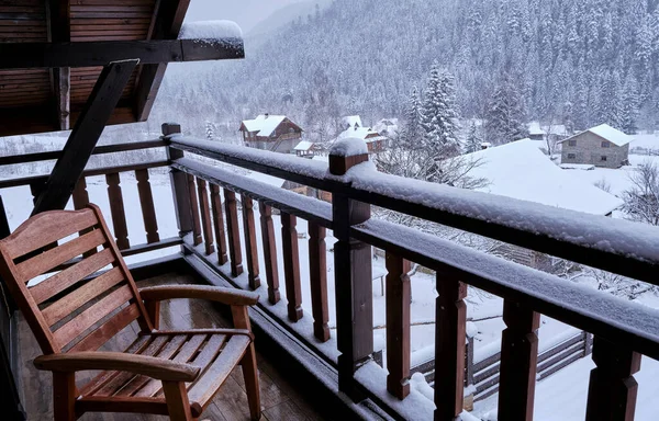 Incredible Mountain View landscape from the hotel balcony. Handmade wicker chair as a decorative element. Winter vacation. Concept of recreation in the mountains.