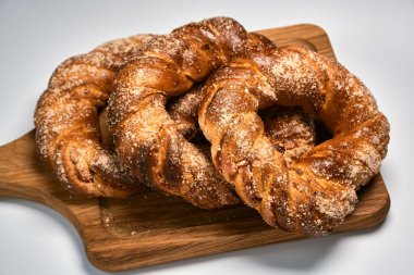 Tahta kesme tahtasındaki lezzetli şeker halka çörekler. Ev yapımı pişirme.