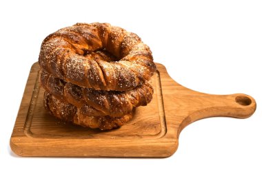 Tahta kesme tahtasındaki lezzetli şeker halka çörekler. Beyaz arka planda izole edilmiş. Ev yapımı pişirme.