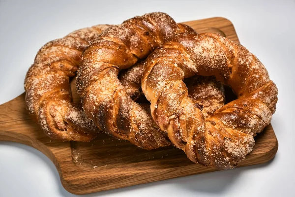 Tahta kesme tahtasındaki lezzetli şeker halka çörekler. Ev yapımı pişirme.