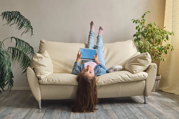 Little Girl Lying Upside Sofa Play Tablet — Stock Photo, Image