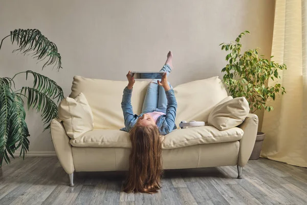 Little Girl Lying Upside Sofa Play Tablet — Stock Photo, Image