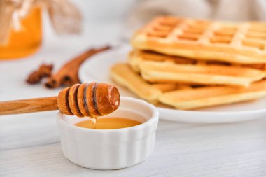Taze Belçika waffle 'larının üzerine bal dökülüyor. Mineral ve vitamin açısından zengin organik sağlıklı kahvaltı. Kahvaltı için eko-yemek. Moda tatlı şekerlemeler