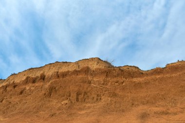 Jeoloji. Çöl manzarası. Kum taşı oluşumunun panorama görüntüsü, kayalık kayalıklar, kum. Sahildeki kumlu uçurumun arka planı veya dokusu, turuncu kireç taşı