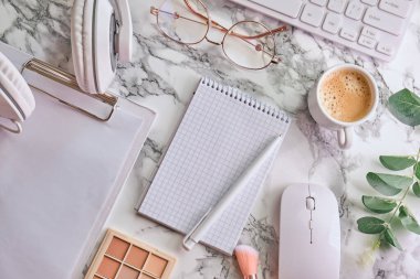 Not defteri, gözlük, kulaklık ve beyaz mermer arka plan görünümlü aksesuarlar. Kadınsı çalışma tarzı konsepti.