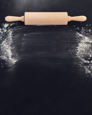 Tahta merdane ve un. Siyah taş arka planda fırın. Üst Manzara. Metin için boş alan. Tarif için arkaplan