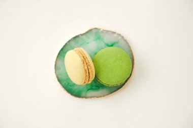 Açık arkaplanlı yeşil mermer tabakta iki badem kurabiyesi, Fransız kurabiyeleri. Minimum konsept. Boşluğu kopyala