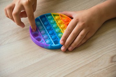 İsimsiz bir çocuk masada renkli şekerlemelerle oynuyor. Çocuk ellerini kapat ve evdeki renkli oyuncakla oyna..