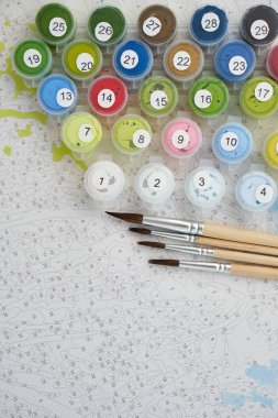 Tuvalin arka planında boyalı ve fırçalı numaralandırılmış kaplar var. Yaratıcı boş zaman aktiviteleri