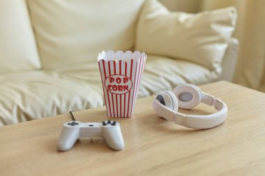 Oyun gecesi. Joystick, oyun konsolu, kulaklıklar ve oturma odasındaki masada patlamış mısır. Boş zaman konsepti