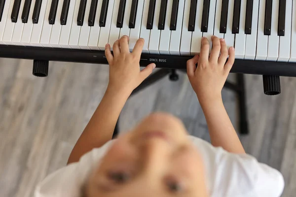 Selective focus of little girl playing the piano. There are musical instrument for concert or learning music. child musician playing the piano, top view