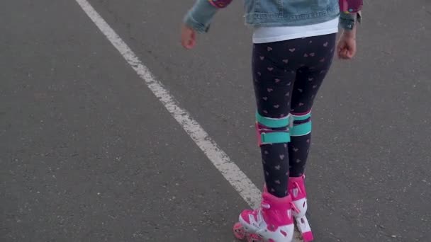 Mała Dziewczynka Nosząca Ochraniacze Kask Bezpieczeństwa Uczy Się Jeździć Rolkach — Wideo stockowe