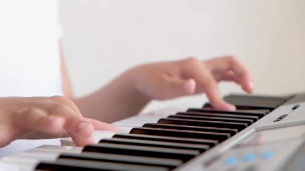 ピアノを弾く子供の指の選択的な焦点 コンサートや音楽学習のための楽器があります ピアノを弾く子供のミュージシャンの手を閉じる — ストック動画