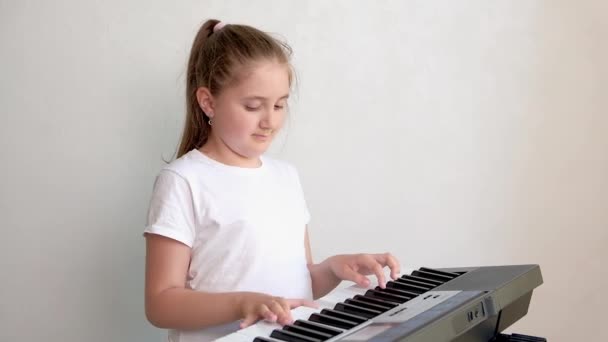 ポートレートのかわいいです幸せな笑顔女の子遊び電気ピアノ — ストック動画