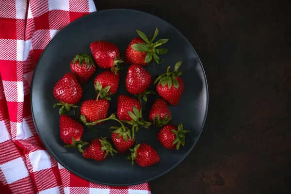 Maturi Fragole Rosse Piatto Nero Con Tovagliolo Rosso Plaid Sfondo — Foto Stock