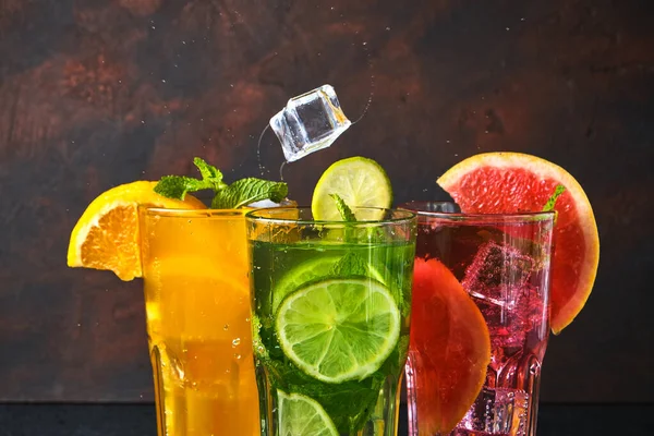 Nahaufnahme Drei Cocktailgläser Mit Einem Fallenden Stück Eis Auf Dunklem — Stockfoto