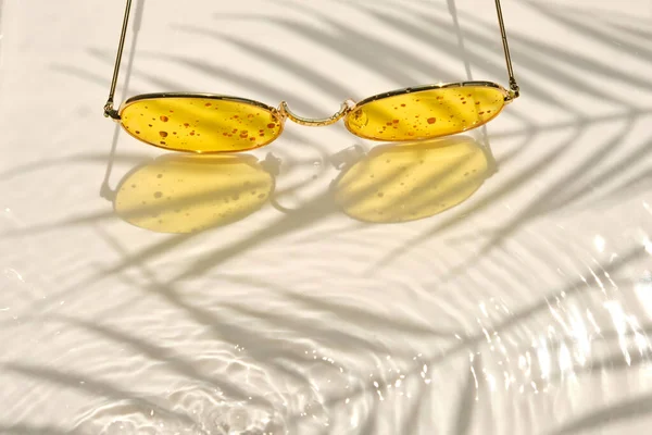 Sunglasses Metallic Frame Yellow Glasses Lie Bright Water Background Shadow — Stock Photo, Image