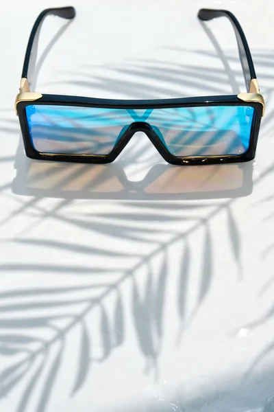Stylish Sunglasses Mirrored Glasses Lie Water Background Shadow Palm Tree — Stock Photo, Image
