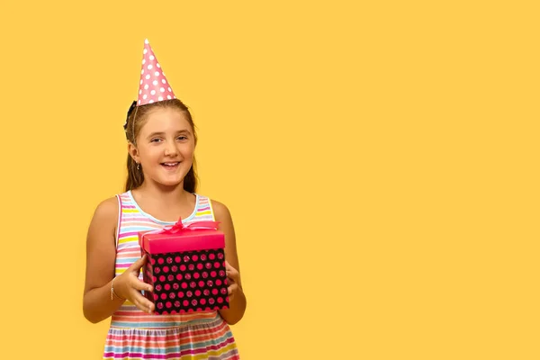 楽しい女性の子供笑顔保持ギフトボックスが興奮していると誕生日プレゼントを得るために驚いて 黄色の背景の上に — ストック写真