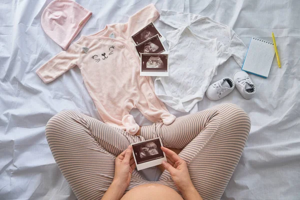 Ovanifrån Gravid Kvinna Sängen Förbereda Baby Kläder Hemma Och Titta — Stockfoto