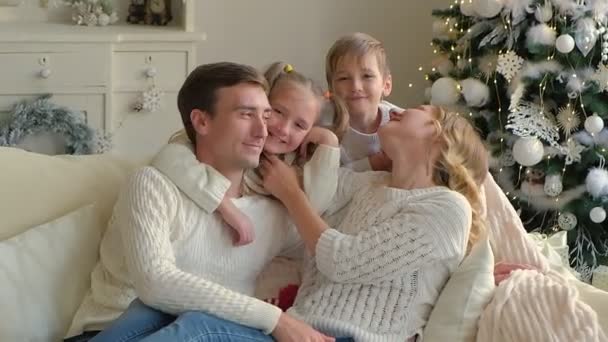 아름다운 소파에서 포옹하고 키스하는 현대의 장식된 아파트에서 크리스마스를 기념하기 대가족 — 비디오