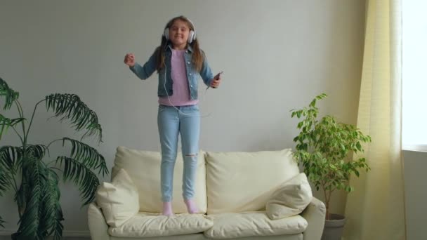 Funny Happy Little Girl Auriculares Están Saltando Sofá Casa Hija — Vídeo de stock