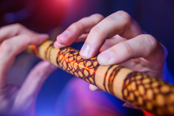 Folk musician in concert plays the melody on the Ethnic Flute